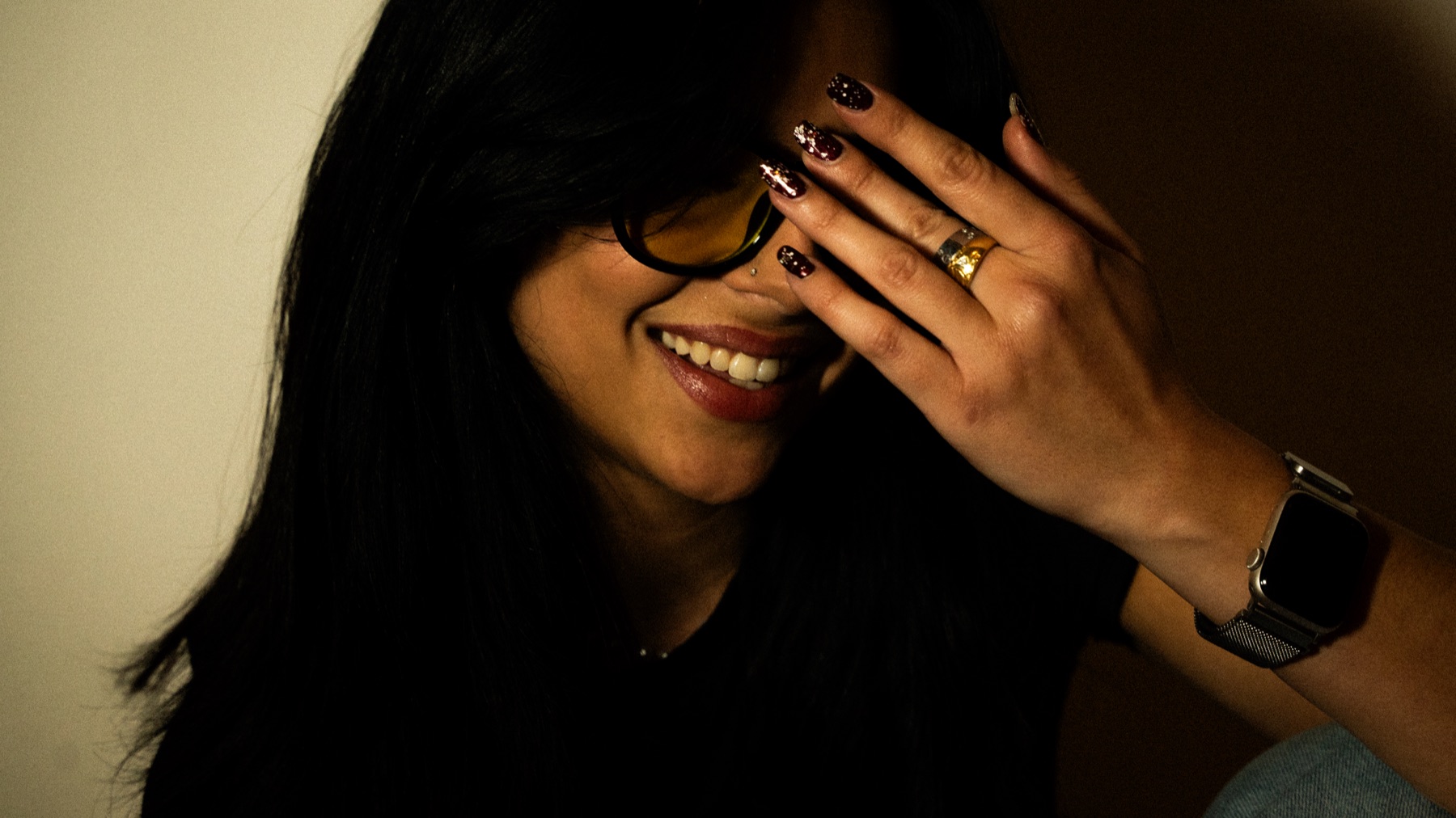 Janis Jane souriante, une main devant ses lunettes